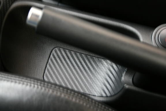 Carbon-look coating under the handbrake